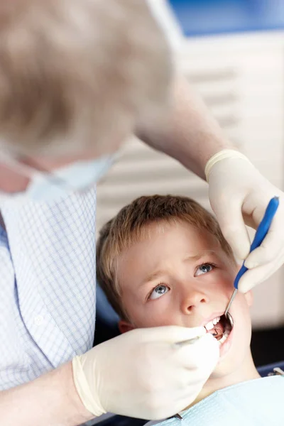 Dottore che controlla i denti dei ragazzi. Vista ad alto angolo del medico che controlla i denti dei ragazzi in clinica. — Foto Stock