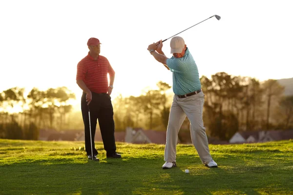 Apuntando al verde. Dos golfistas masculinos pasando por una ronda de golf. —  Fotos de Stock