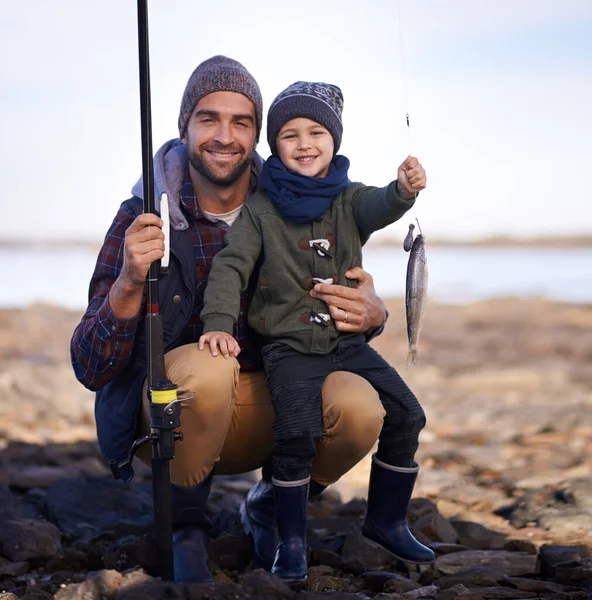 Bir puan bana, babama yok. Babasıyla yakaladığı balığı tutan küçük şirin bir çocuğun portresi.. — Stok fotoğraf
