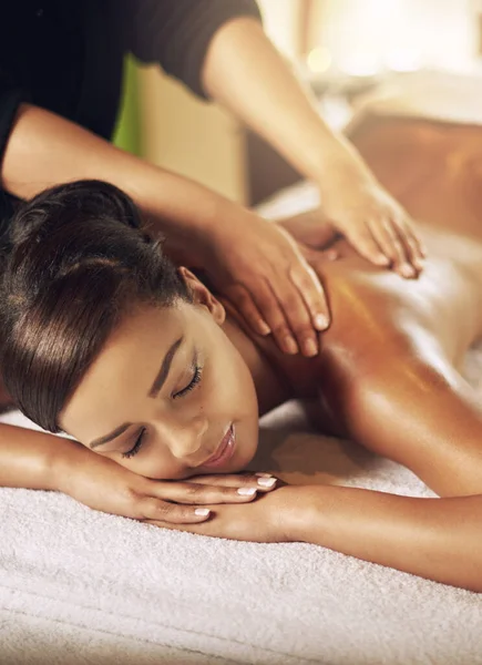 Massajar o corpo e a mente. Tiro de ângulo alto de uma jovem mulher recebendo uma massagem no spa. — Fotografia de Stock