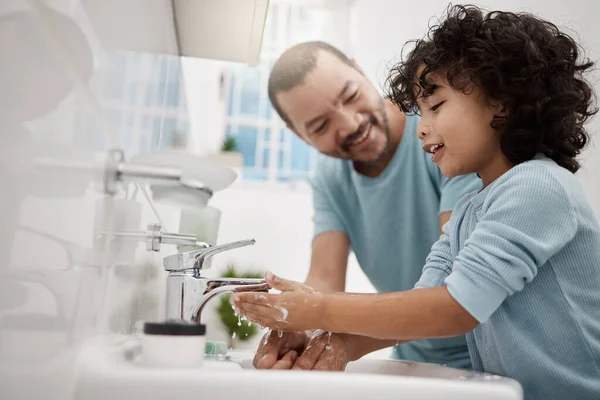 Nu känner du dig extra fräsch. Skjuten av en far som hjälper sin son att tvätta händerna och ansiktet på en kran i ett badrum hemma. — Stockfoto