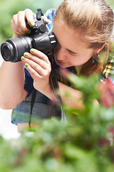 Schwerpunkt Naturfotografie. Eine hinreißende junge Frau fokussiert durch die Linse ihrer Kamera. — Stockfoto