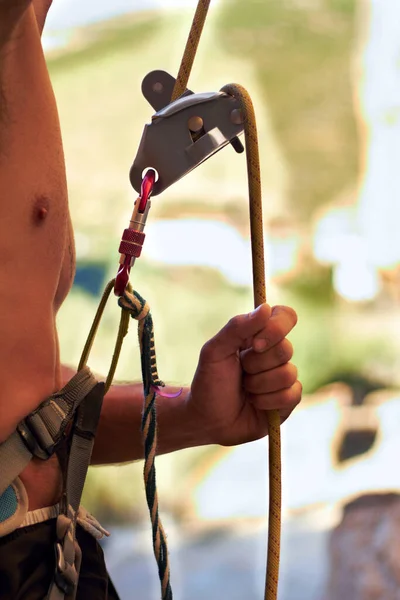 Para a subida. Tiro cortado de um jovem alpinista de pé e ajustando seus arreios. — Fotografia de Stock