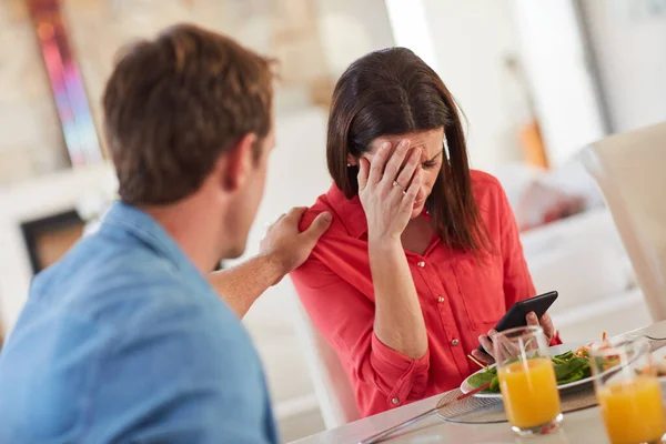 Las malas noticias pueden llegar en cualquier momento. Un disparo de un hombre consolando a su esposa mientras recibe malas noticias durante el almuerzo. — Foto de Stock