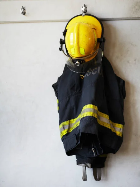 Upp med utrustningen. Skott av en brandman uniform hängande på väggen. — Stockfoto
