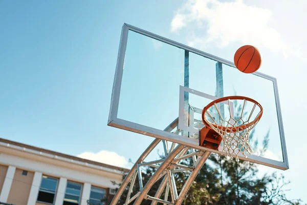 Thats going to be an airball shot. Still life shot of a basketball landing into a net on a sports court. — Stock Photo, Image