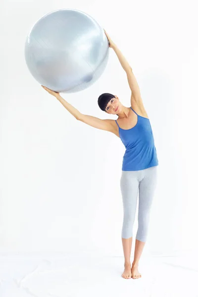 Mit Geräten, die ihr Training ankurbeln. Fit junge Frau beim Gymnastikball. — Stockfoto