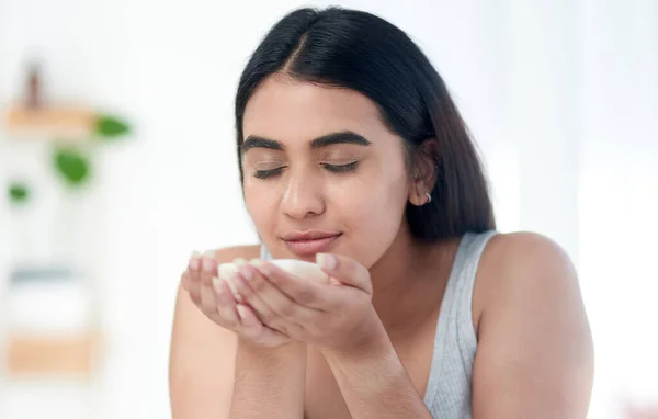 Im about to smell amazing. Shot of young woman smelling some skincare product. — Stock Photo, Image