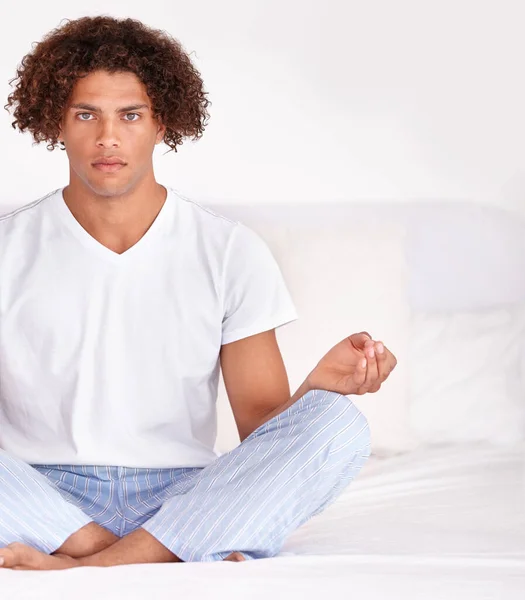 Dikkatini topluyor. Yakışıklı, genç ve etnik bir erkeğin yatakta sakince oturup meditasyon yaparken çekilmiş portresi.. — Stok fotoğraf