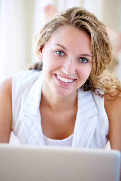 Korzystanie z prostoty technologii bezprzewodowej. Portret pięknej młodej kobiety przeglądającej internet na laptopie leżącej na podłodze. — Zdjęcie stockowe