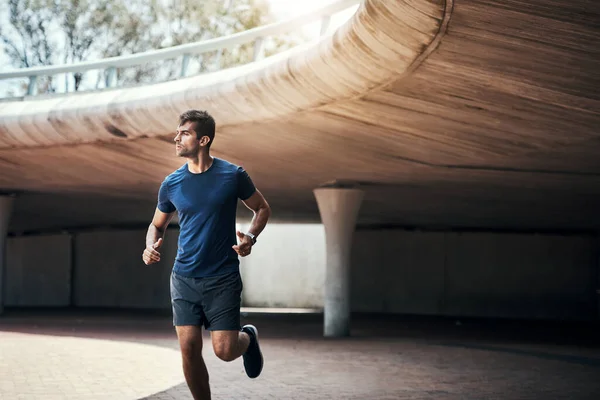 Agarra-te a toda a determinação que tens. Tiro de um jovem desportivo exercitando ao ar livre. — Fotografia de Stock