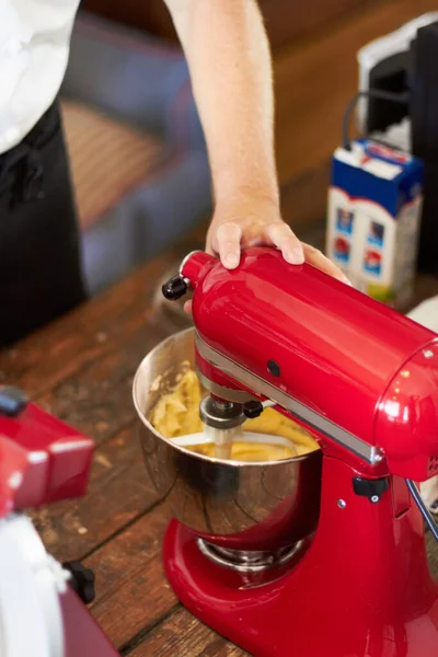 Mescolare gli ingredienti per il risultato perfetto. Un panettiere che mescola il mix di cupcake con il suo mixer. — Foto Stock