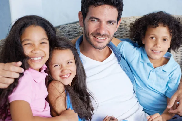 We delen de sterkste familiebanden. Portret van een gelukkige alleenstaande ouder familie zittend op een bank en lachend naar de camera. — Stockfoto