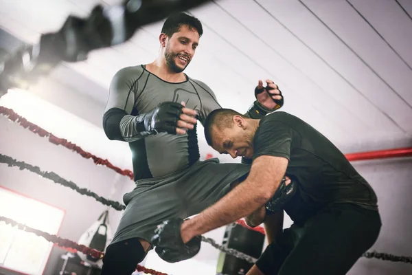 Was für ein Schuss aus dem Nichts. Aufnahme von zwei jungen männlichen Boxern, die sich während eines trainingssparenden Kampfes in einem Boxring in einem Fitnessstudio gegenüberstehen. — Stockfoto
