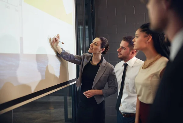 Ihr Team in den Geschäftsprozess einzubinden. Aufnahme einer Führungskraft bei einer Präsentation auf einer Projektionswand vor einer Gruppe von Kollegen in einem Sitzungssaal. — Stockfoto