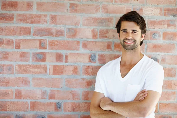 Comfortable in my own skin. An attractive male leaning against a wall and smiling. — Stock Photo, Image
