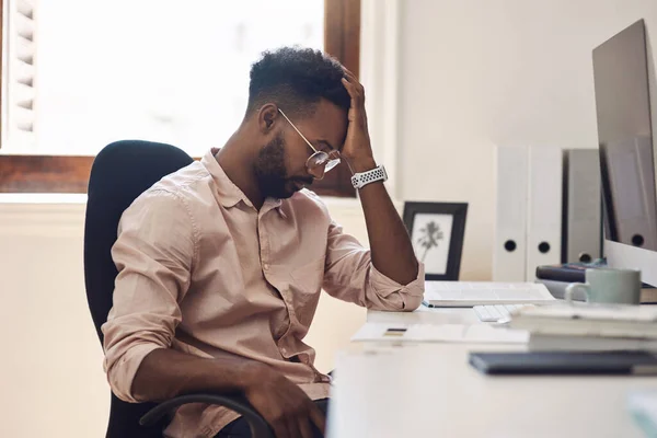 Enfrentando um desafio difícil em sua jornada de trabalho. Tiro de um jovem homem de negócios que parece cansado enquanto trabalhava em um escritório. — Fotografia de Stock