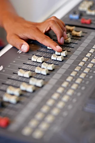 Fine-tuning the mix. Cropped close-up image of a hand moving a slider on a mixing desk. — Stock Photo, Image