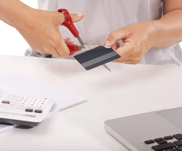 Ваші покупки занадто великі. Крупним планом жінка вирізає свою кредитну картку з ноутбуком і калькулятором перед нею . — стокове фото
