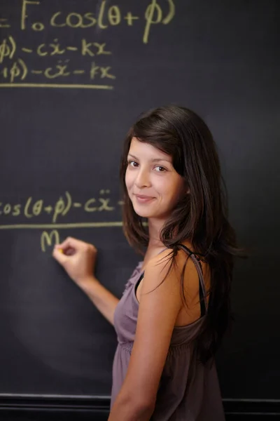 Zeigt ihre Methodik. Eine junge attraktive Inderin, die im Unterricht eine Mathe-Aufgabe an der Tafel löst. — Stockfoto