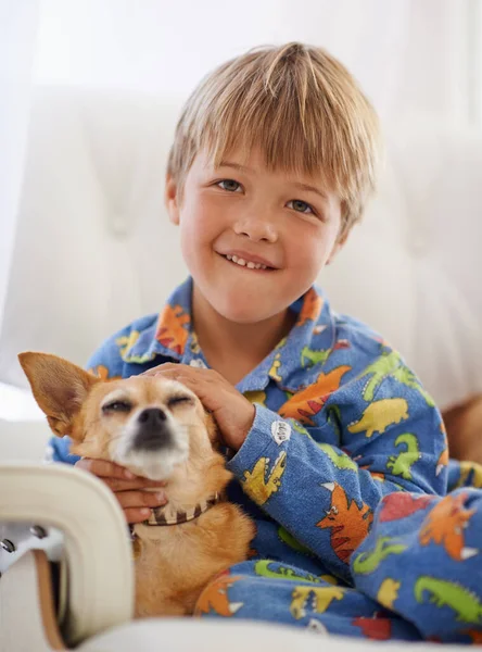 Kuscheln mit seinem alten Freund. Ein süßer kleiner Junge kuschelt seinen Hund auf der Couch. — Stockfoto