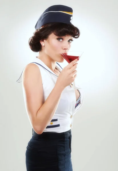 Tar bort kanten. Bild av en fantastisk kvinna utklädd till sjöman flicka och dricka en martini. — Stockfoto