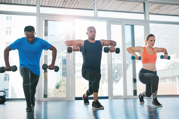 Hacer ejercicio con otros hace que sea fácil mantenerse motivado. Tiro de personas haciendo ejercicio en el gimnasio. — Foto de Stock