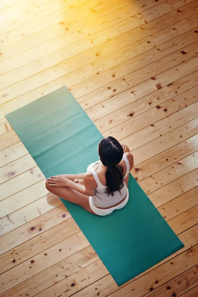 Dándole un entrenamiento a su mente. Foto de ángulo alto de una joven haciendo yoga en el interior. — Foto de Stock