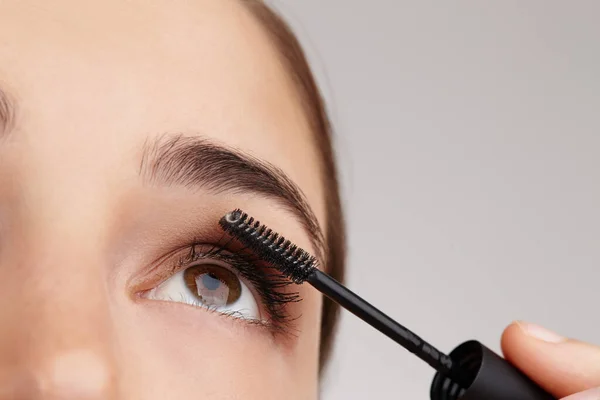 Eenvoudige stappen om schoonheid te perfectioneren. close-up shot van een jonge vrouw van toepassing mascara in studio. — Stockfoto