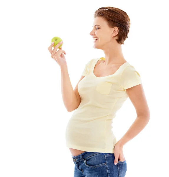 Une alimentation saine pour le bébé. Une femme enceinte regardant une pomme verte croquante isolée sur un fond blanc. — Photo