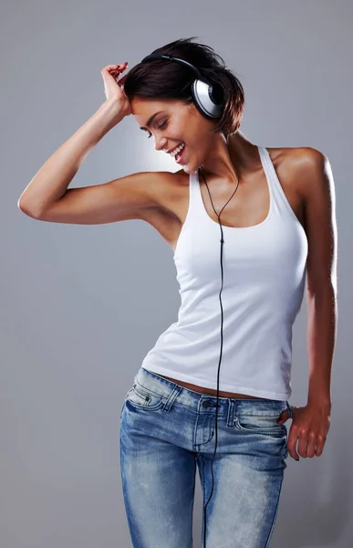 Fun is her middle name. Cropped shot of an attractive young woman dancing with total freedom. — Stock Photo, Image