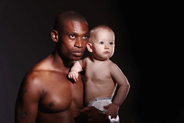 Gerações de homens. Concept shot of a man holding a little boy in his arms against a black background. — Fotografia de Stock
