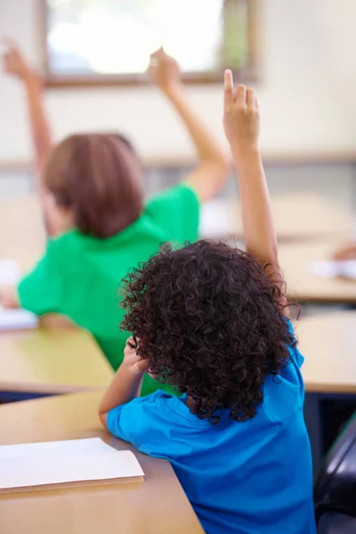 To pilni studenci. Zdjęcie uczniów trzymających ręce do góry, by odpowiedzieć na pytanie w klasie.. — Zdjęcie stockowe
