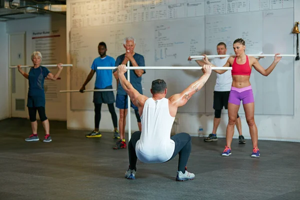 Führend in seiner Klasse. Aufnahme einer Fitnessgruppe, die im Fitnessstudio trainiert. — Stockfoto
