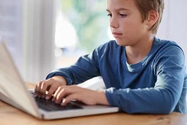 Τελειώνει τα μαθήματά του σε μια στιγμή. Πυροβολισμός ενός νεαρού αγοριού χρησιμοποιώντας ένα φορητό υπολογιστή στο σπίτι. — Φωτογραφία Αρχείου