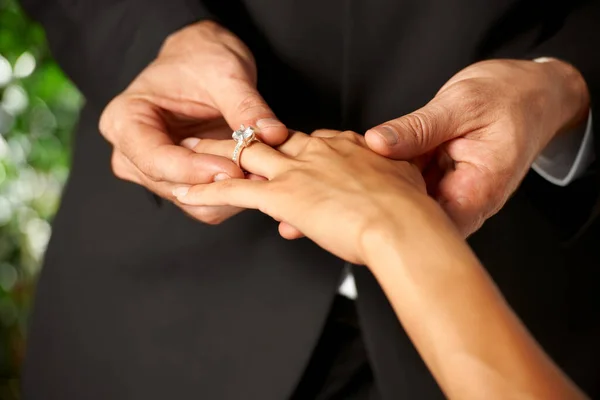 Ze beloven hun liefde. Gehakt uitzicht van een bruidegom glijden een ring op zijn bruiden vinger. — Stockfoto