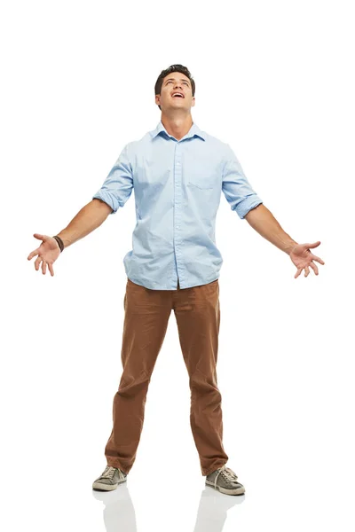 Allvarligt. En ung man tittar upp mot himlen med öppna armar - isolerad. — Stockfoto