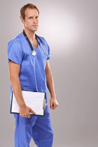 É sério em relação à cirurgia. Estúdio retrato de um belo cirurgião masculino segurando uma área de transferência. — Fotografia de Stock