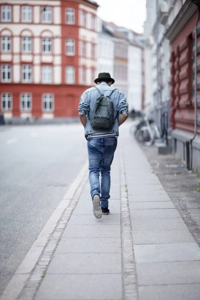 Yolda geliyor. Şehir caddesinde yürüyen genç bir adamın arka görüntüsü.. — Stok fotoğraf