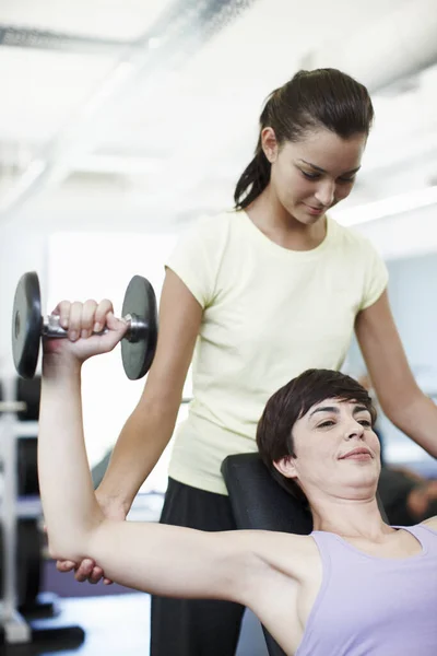 Personal training is about motivation. Cropped shot of an attractive young woman training on the weights with her personal trainer. — Stock Photo, Image