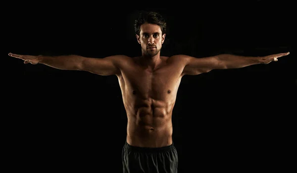 Perfect form. Handsome topless man raising his arms to his side - Isolated on black. — Stock Photo, Image