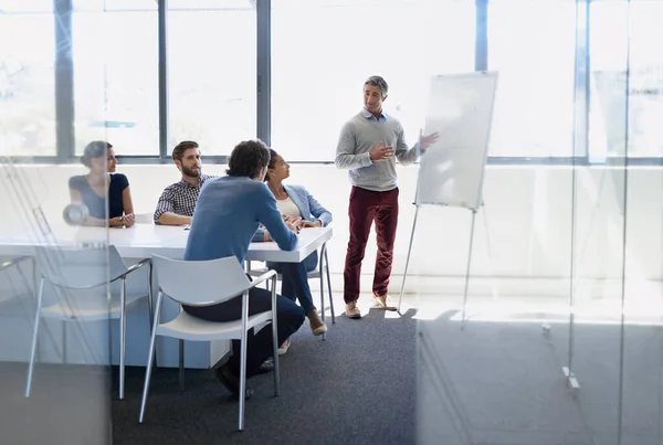 Beginnen wir den Tag mit einer Strategiesitzung. Ein Geschäftsmann bei einer Präsentation mit einem Whiteboard während einer Vorstandssitzung. — Stockfoto