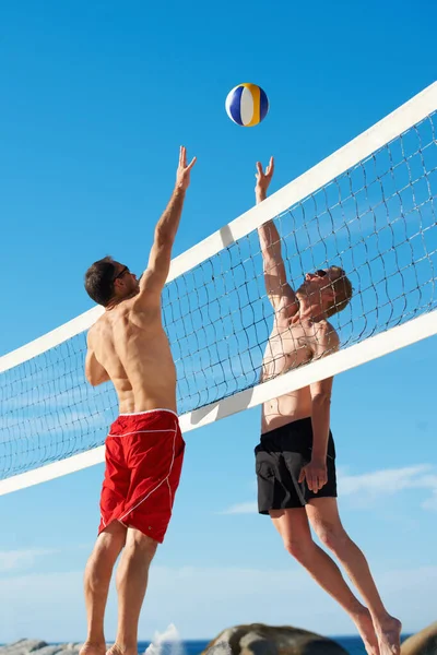 В разгар игры. Съемка игры в пляжный волейбол в солнечный день. — стоковое фото