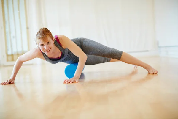 Cuidar do corpo dela através do ioga. Tiro de uma mulher fazendo exercícios de espuma de rolo durante um treino de ioga. — Fotografia de Stock