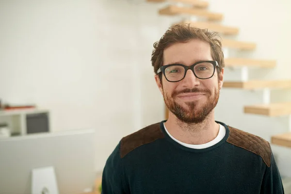 Shot of a young entrepreneur using a mobile phone in his office. Portrait of a confident young entrepreneur standing in his office. — Stock Photo, Image