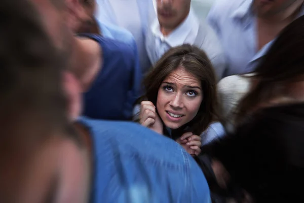 사람들 속에서 뒹굴고. 군중 속에 갇혀 있는 두려움에 질린 한 젊은 여자의 사진. — 스톡 사진
