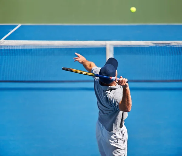 Il se montre à chaque entraînement de tennis. Prise de vue d'un homme essayant de rendre une balle sur un court de tennis. — Photo