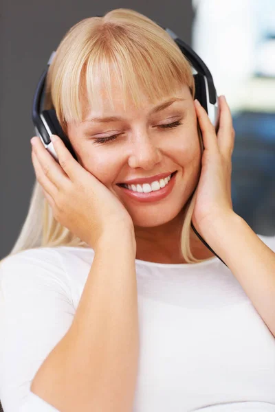 Mujer con los ojos cerrados escuchando música. Primer plano de la joven relajada escuchando los auriculares. — Foto de Stock