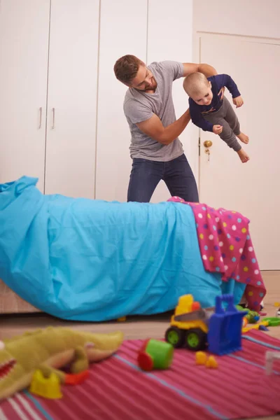 Los papás son los mejores. Un padre joven jugando con su hijo pequeño en casa. — Foto de Stock