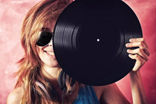Golden Oldies are still the best. Fun portrait of a young woman holding a vinyl record up to her face. — Stock Photo, Image